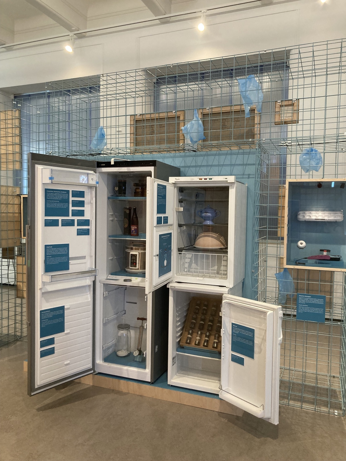 mehrere Kühlschränke aus verschiedenen Epochen, innerhalb der Kühlschränke sind andere Methoden der Kühlung von Lebensmitteln ausgestellt