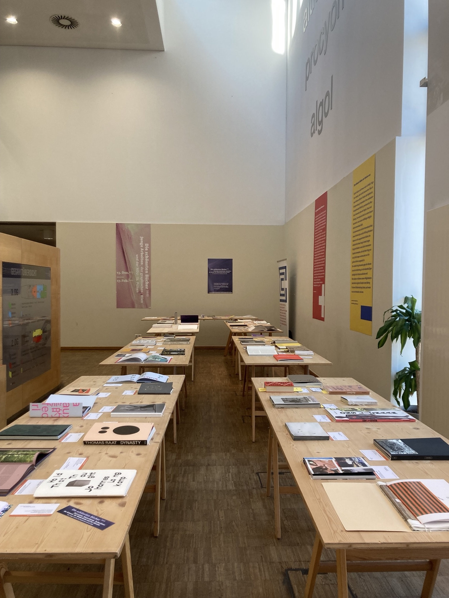 Überblick über die Ausstellung, links und rechts sind drei Tische aneinander gereiht, darauf liegen verschiedene Bücher